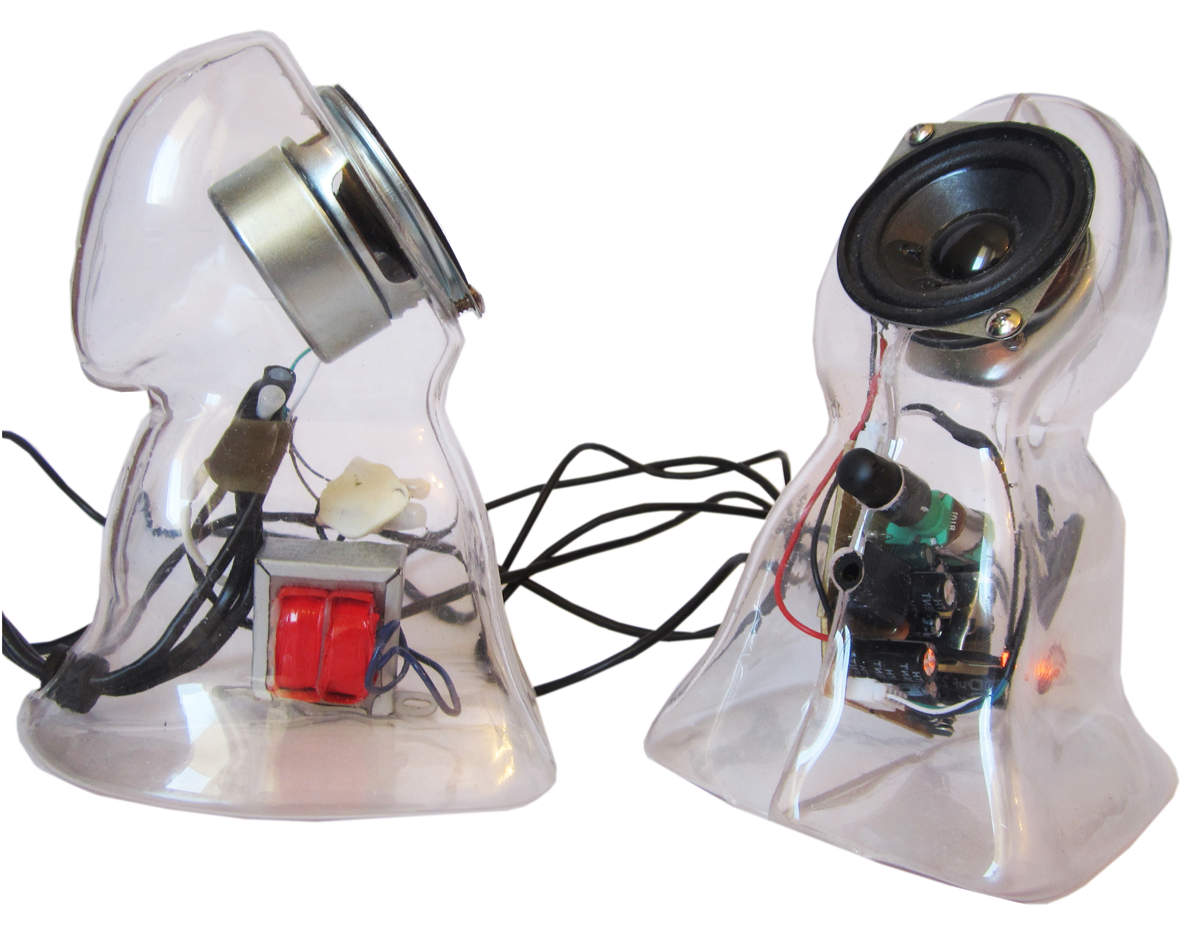 Two clear plastic speakers in the shape of cloaked ghosts. The speaker is located in the ghost’s “face” while the electronics, sound dial, and headphone port are located in the “body”. 