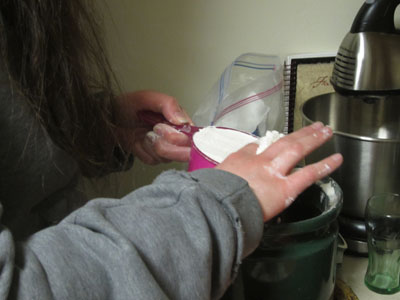 User carefully leveling off flour with finger.