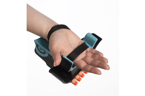 Refined model attached to users’ hand by two straps. Their thumb rests on one of the side thumb triggers. 