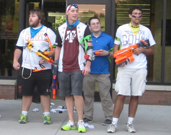 A group of four users with hand drawn matching t-shirts. One of the blasters they have is a toy bow.