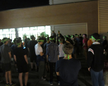 A crowd of people with matching headbands listen to someone in the group speaking.