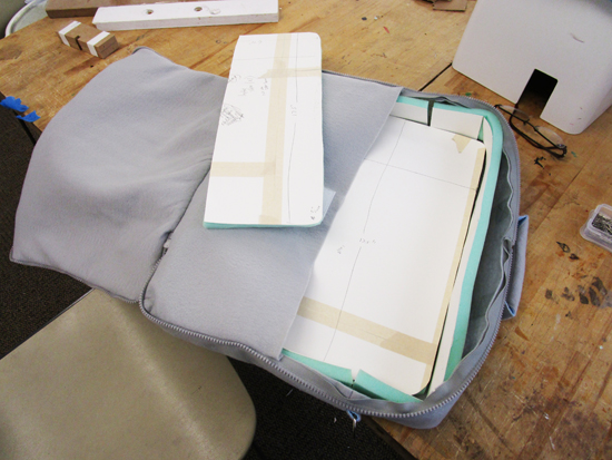 Fabric bag. Flat foam pieces are being fitted into interior prior to lining being sewn on.